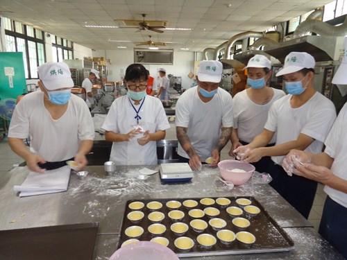The baking instructor teaches the inmates to make egg tarts.